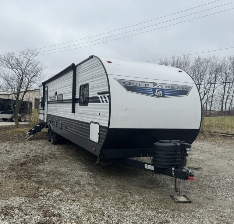Travel trailer in rural outdoor setting.